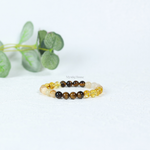 Beaded solar plexus chakra bracelet with yellow and brown beads on a white background