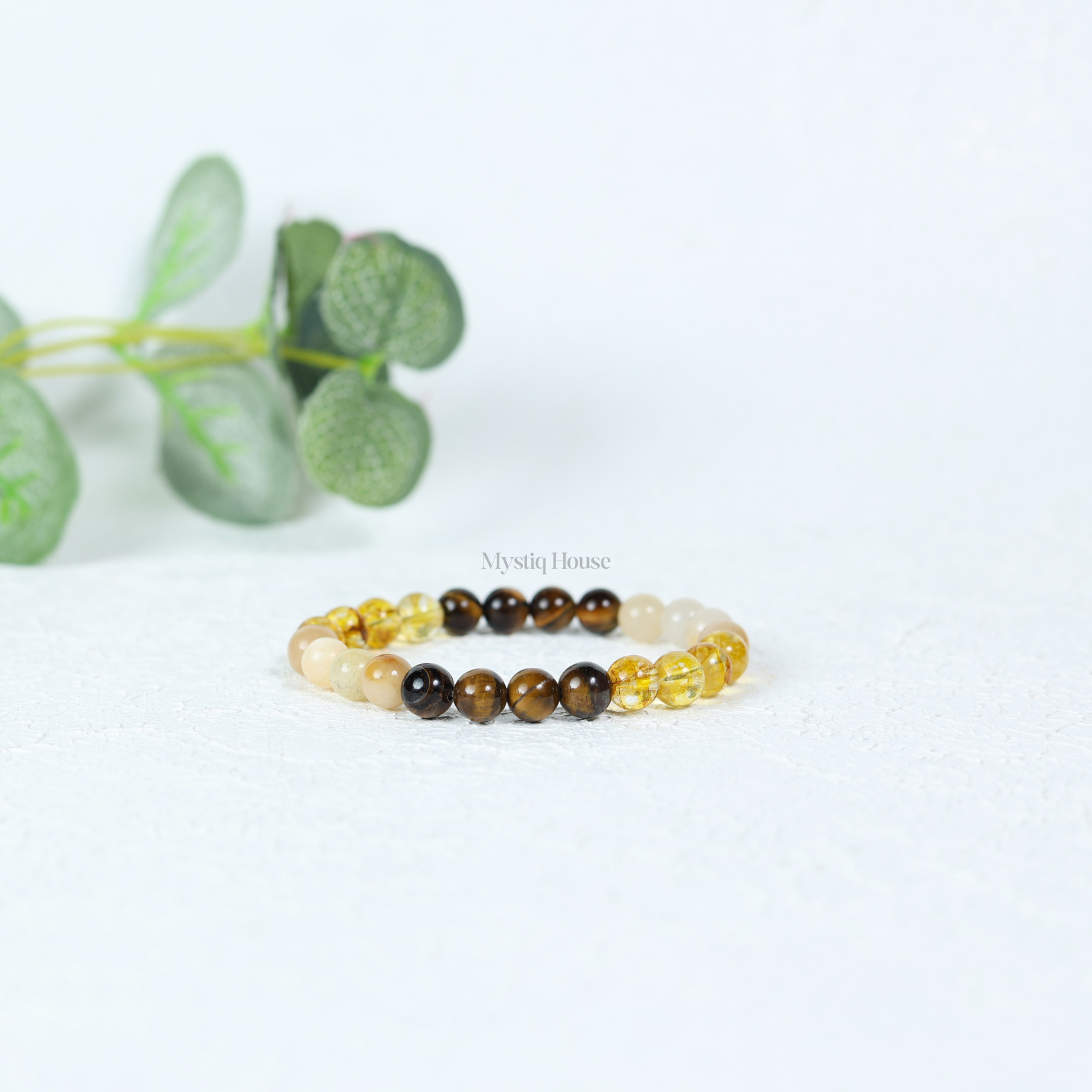 Beaded solar plexus chakra bracelet with yellow and brown beads on a white background